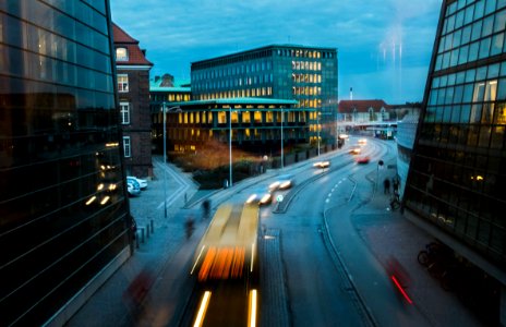 timelapse photography of vehicle near curtain buildings