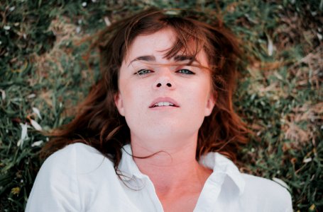 woman lying on grass field