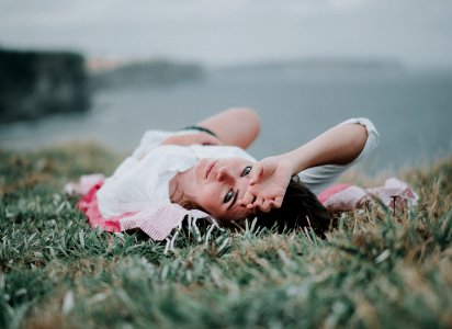 selective focus of woman lying on green grass photo