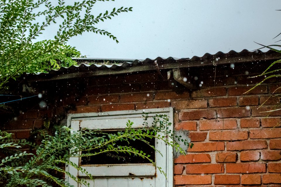 rain pouring on brick wall house