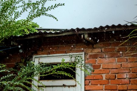 rain pouring on brick wall house photo