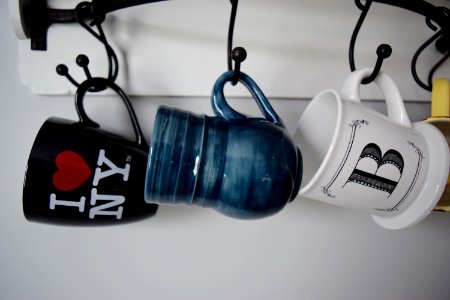 three hanged assorted-color ceramic mugs photo