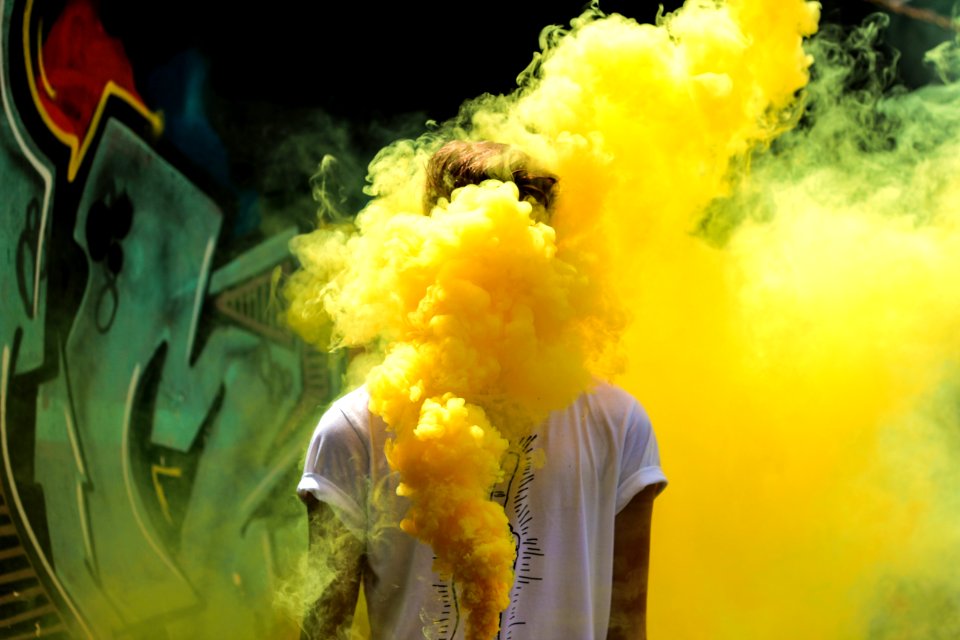 Yellow smoke coming from a tagger's spray paint can.