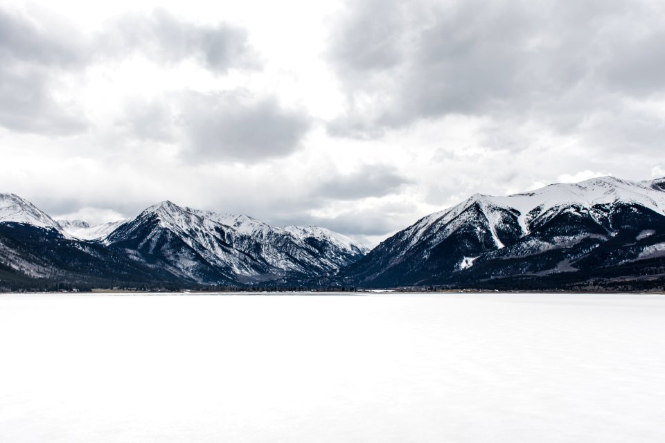 body of water near mountain peak during daytime