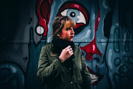 woman in green coat near graffiti