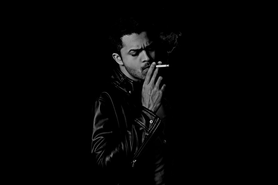grayscale photo of man smoking cigarette