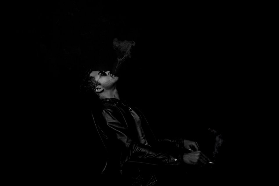 grayscale photo of man with cigarette stick
