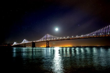 Moon over the San Francisco – Oakland Bay suspension Bridge reflected on the water below photo