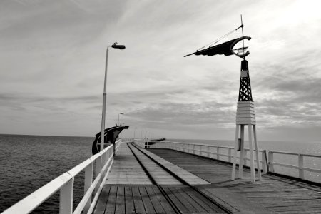 wooden wind vane on bridge near the body of water photo