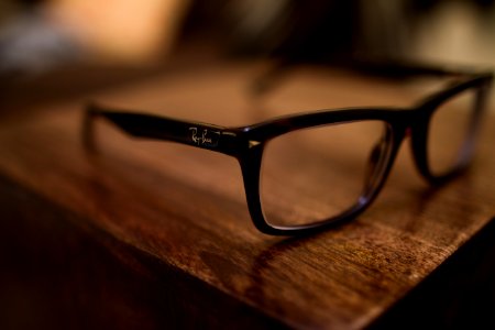 eyeglasses with black frames on brown table photo