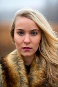 woman looking at camera wearing brown fur scarf photo