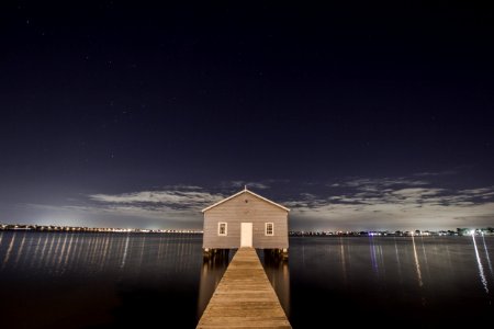white and gray wooden house in the middle of body of water