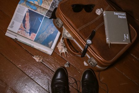 brown suitcase beside open book photo