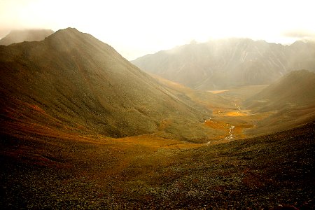 green mountains covered with fog during daytime