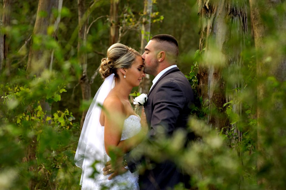 kissing groom and bride during daytime photo