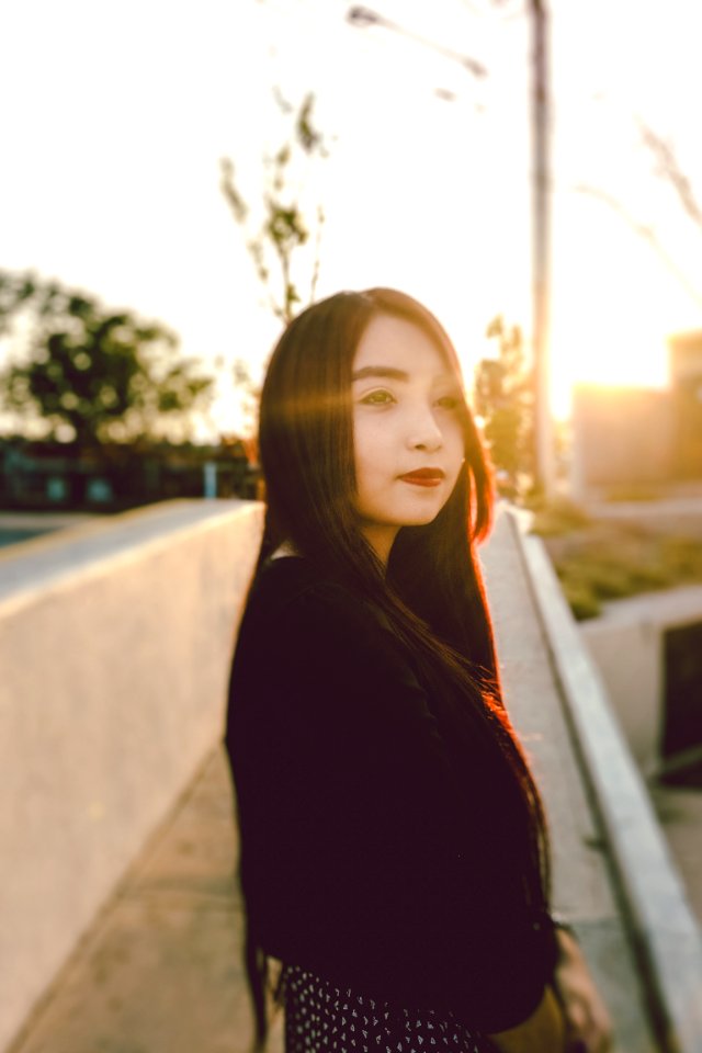 woman in black blazer beside white wall