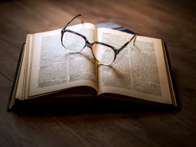 framed eyeglasses on top open book photo