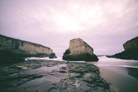 landscape photo of white and grey rocky island near ocean under cloudy sky photo