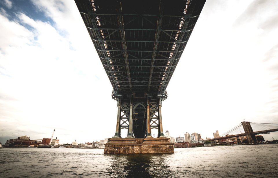 grey steel bridge over sea under grey and blue sky photo