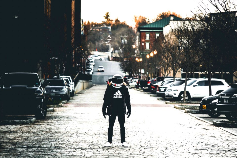 person wearing jacket and helmet on road