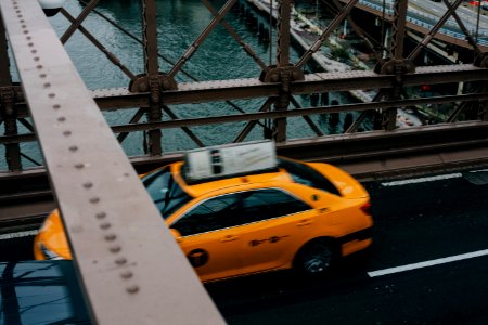 yellow sedan crossing bridge