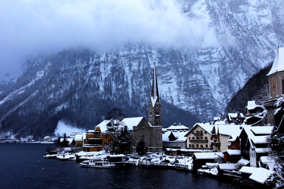 village near body of water and moutain