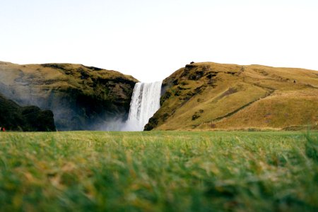 green grass field near waterfalls photo