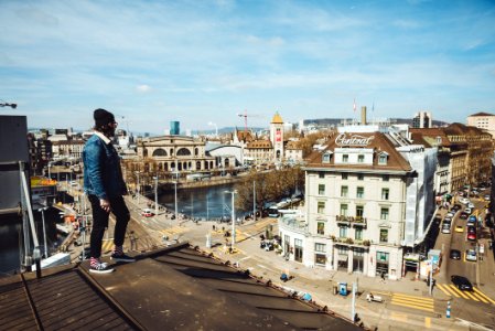 man standing on roof near buildings during daytime photo