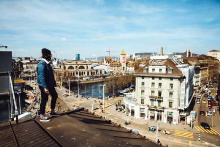 man standing on roof near buildings during daytime