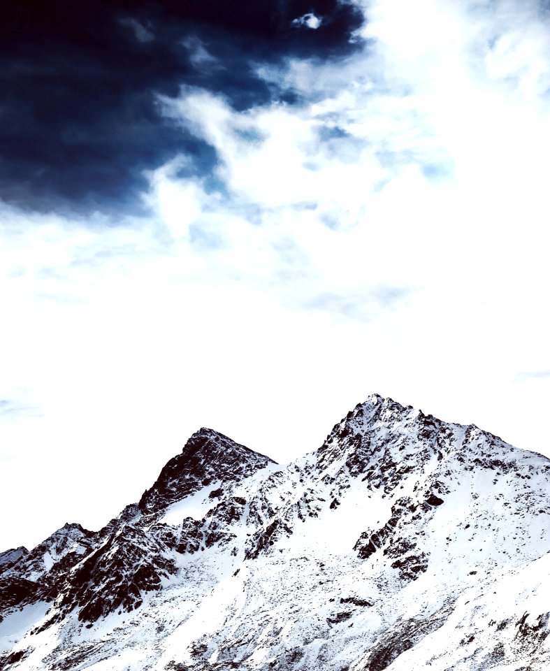 mountain filled of snow under gray cloud