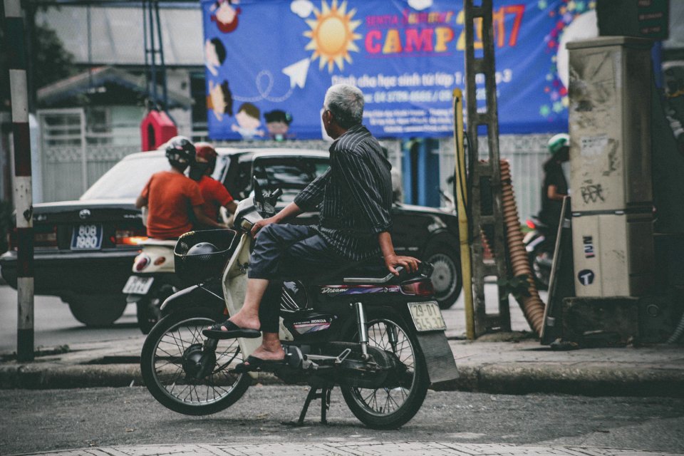 man riding white and black motor scooter photo