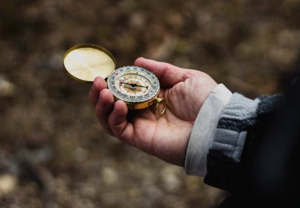 person using white and gold compass photo