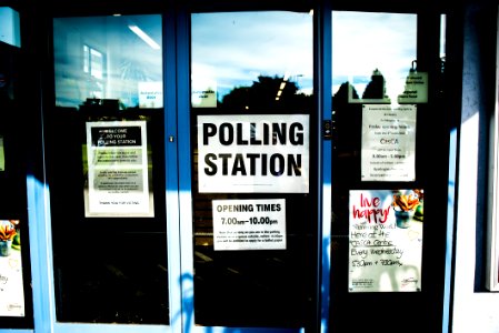 polling station poster on clear glass door photo