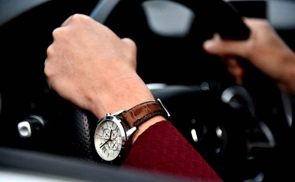 person driving car with black steering wheel photo