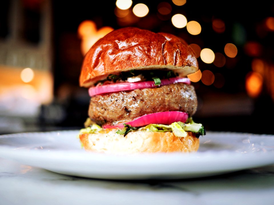 shallow focus photography of hamburger on white ceramic plate