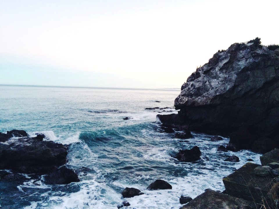 ocean waves near rocks during daytime