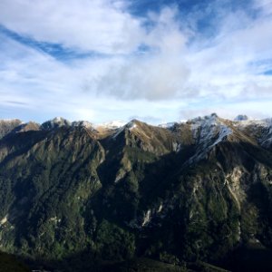 mountains with trees under cloudy sky photo