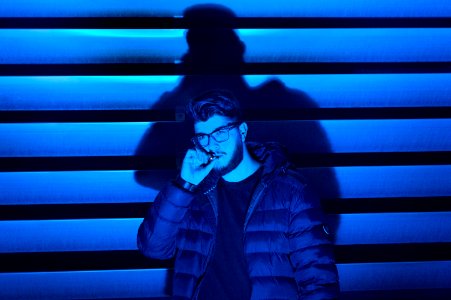 man smoking standing near wall