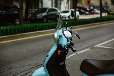 blue motor scooter parked beside road photo