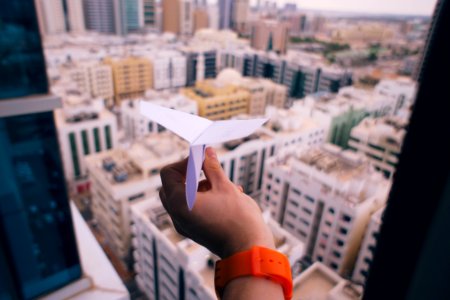 shallow focus photography of person holding paper plane photo