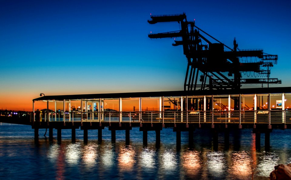 black wooden dock on body of water during sunset