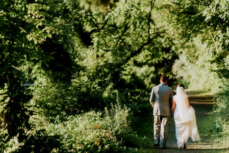 groom and bride walking on forest pathway photograph photo