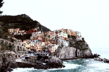 white and brown houses on cliff beside a sea at daytime photo