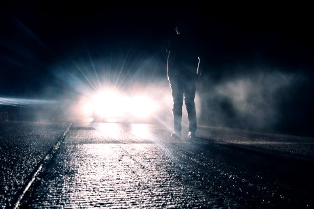 man standing in front of lighted car photo