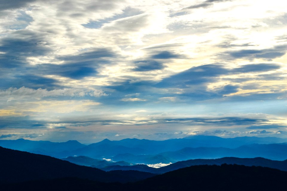 silhouette of mountains under sea clouds