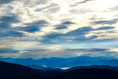 silhouette of mountains under sea clouds