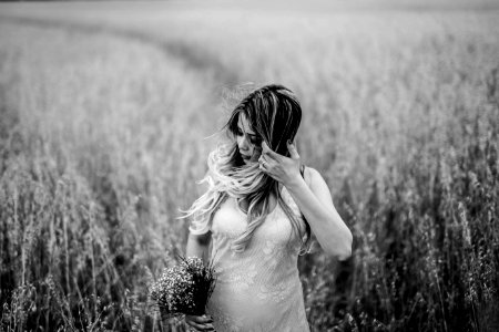 grayscale photo of woman surrounded by grass photo