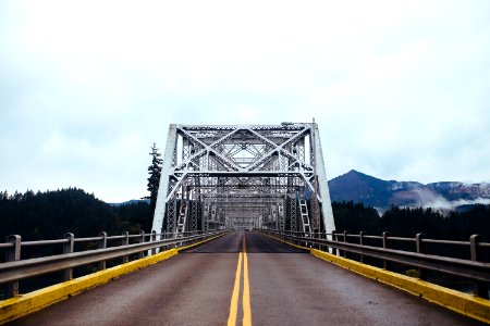 white and gray steel bridge with two yellow lanes