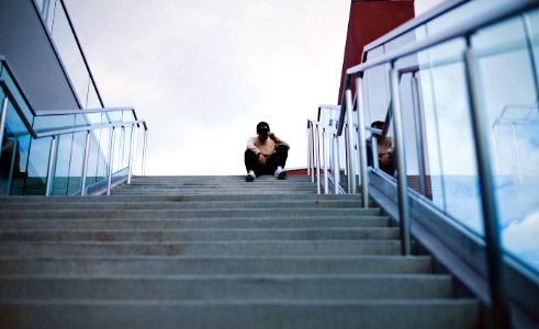 worm's eye view of man sitting on staircase photo