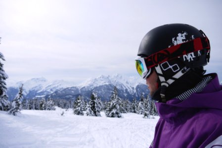 man wearing black helmet and snow goggles under white sky photo